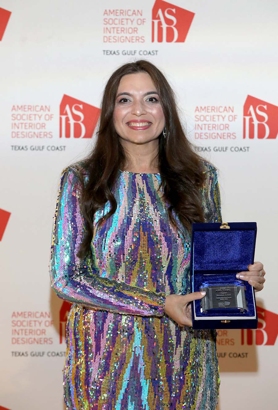 Saima Seyar, ASID RID holding her merit award by ASID Texas Gulf Coast chapter.